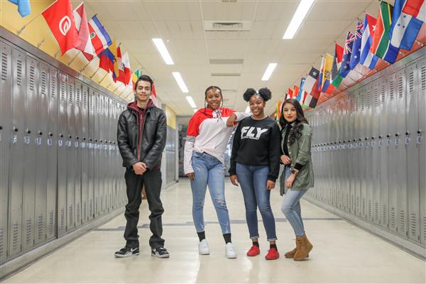 Four high school students standing in a hallway 